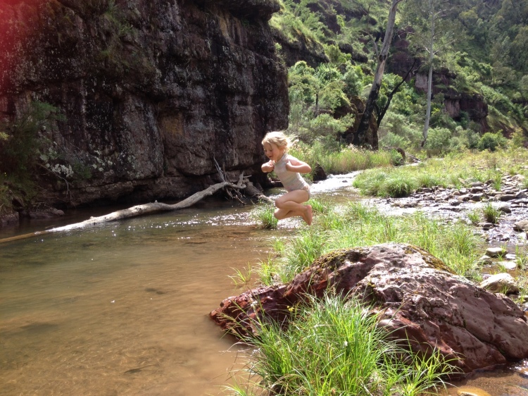 Ainsley jumping into river from rock