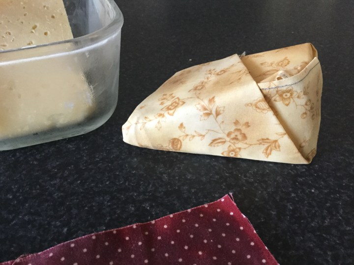 Homemade beeswax wrap wrapping parmessan cheese.