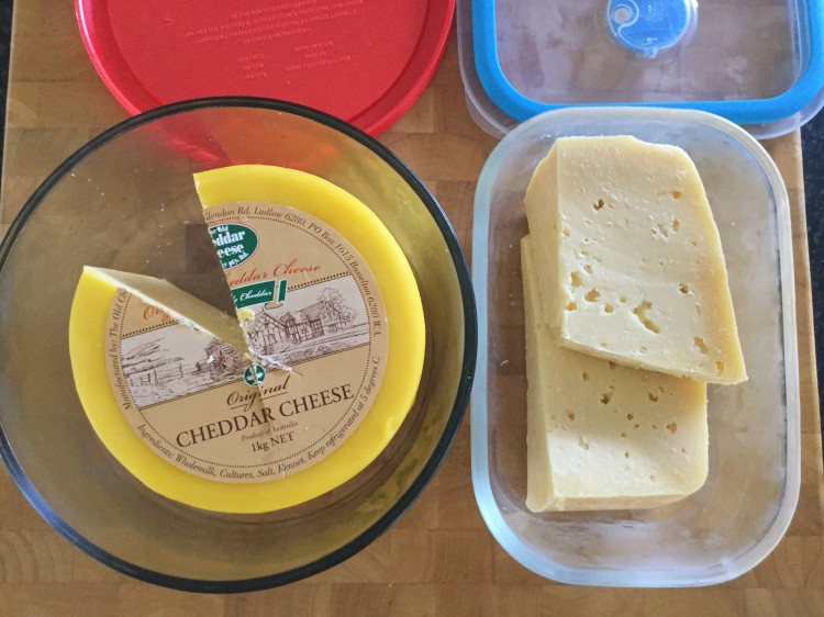 Cheddar and parmesan cheese stored in glass containers.