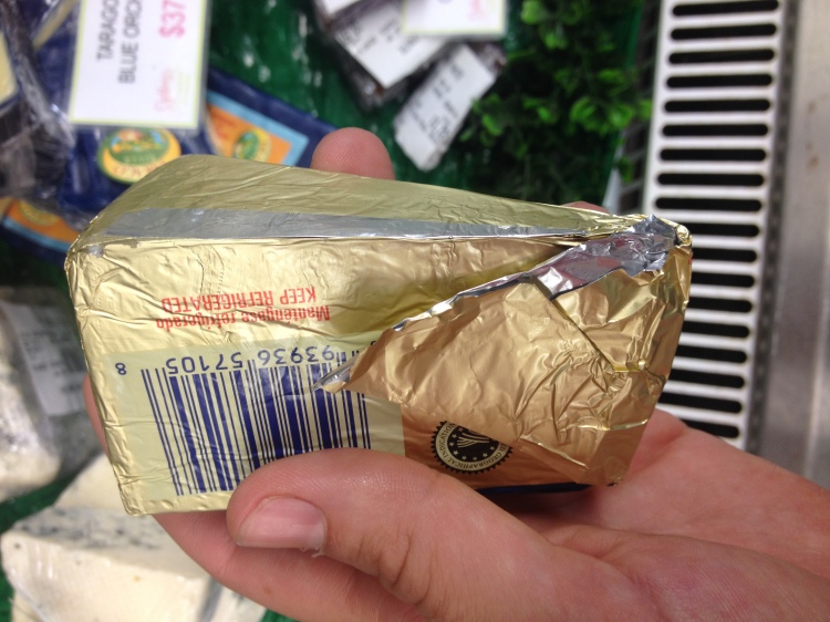 A wedge of blue cheese wrapped only in foil.