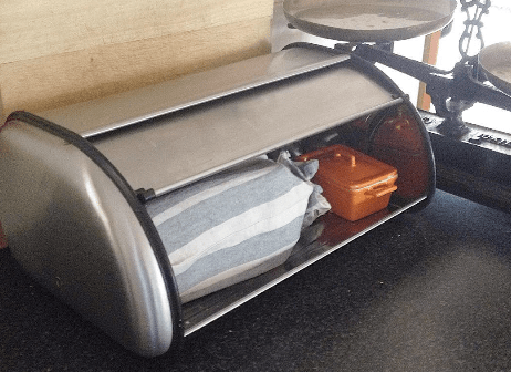 My bread stored in a cloth bag in a bread tin along with a dish of butter.