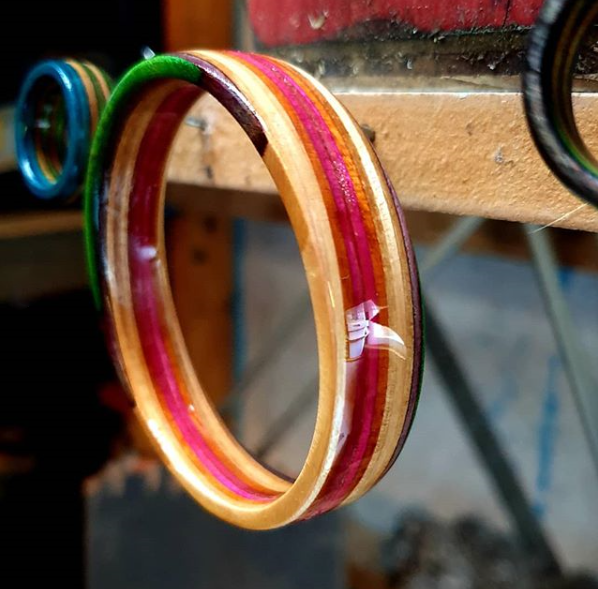 A bangle made from upcycled broken skateboards hanging on a nail in The Hairy Handyman's workshop.